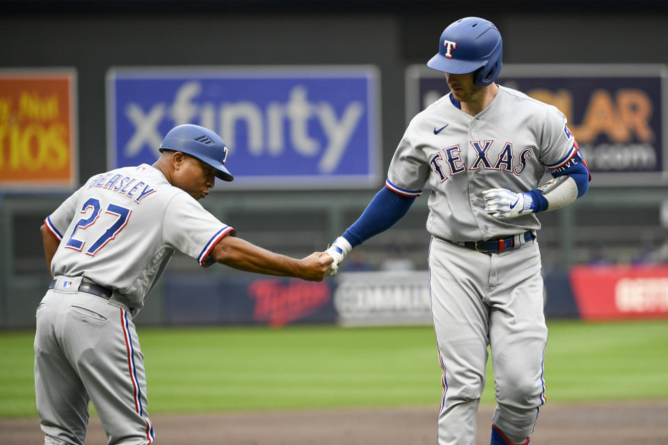 Texas Rangers' Mitch Garver, right, celebrates with third base coach Tony Beasley after hitting a home run against the Minnesota Twins during the second inning of a baseball game Saturday, Aug. 26, 2023, in Minneapolis. (AP Photo/Craig Lassig)