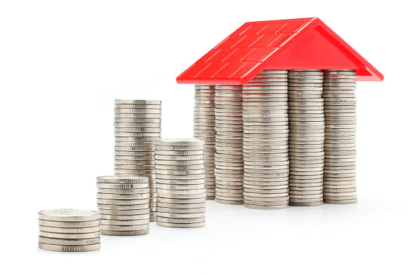 stack of coins and money house with the red roof