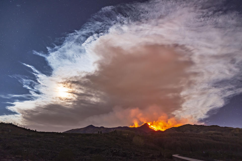 Smoke fills the sky during an eruption of Mt. Etna volcano, near Catania in Sicily, southern Italy, early Tuesday, Feb. 23, 2021. The explosion started before midnight on Monday night, provoking a huge eruption plume that rose for several kilometers from the top of Etna, as reported by The National Institute of Geophysics and Volcanology, Etneo Observatory. (AP Photo/Salvatore Allegra)