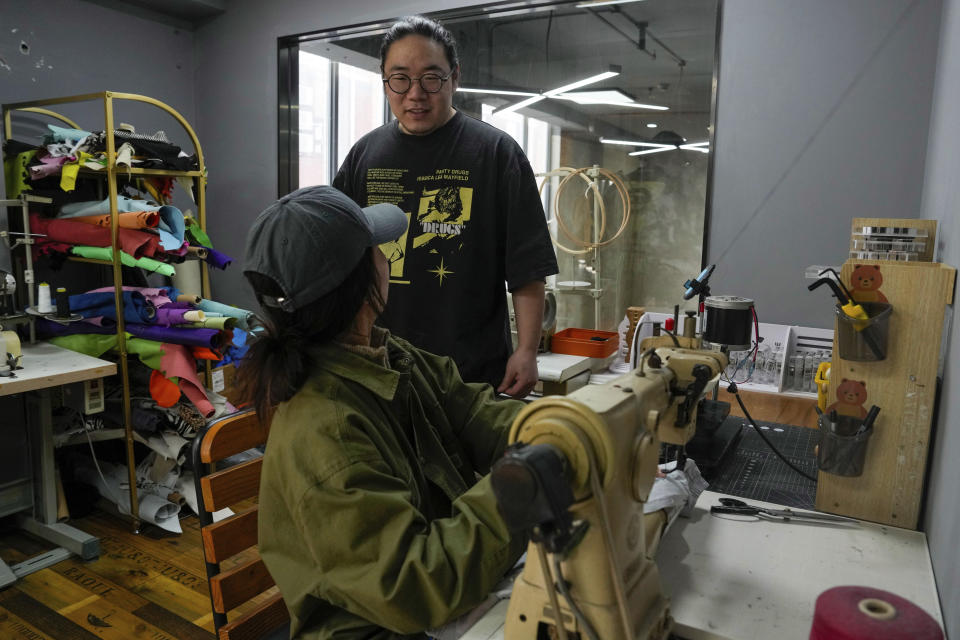 Founder Da Bao speaks to a worker at a workshop for Times Remake, a Shanghai-based brand that takes secondhand clothes and refashions them into new garments in Shanghai on March 18, 2024. (AP Photo/Ng Han Guan)