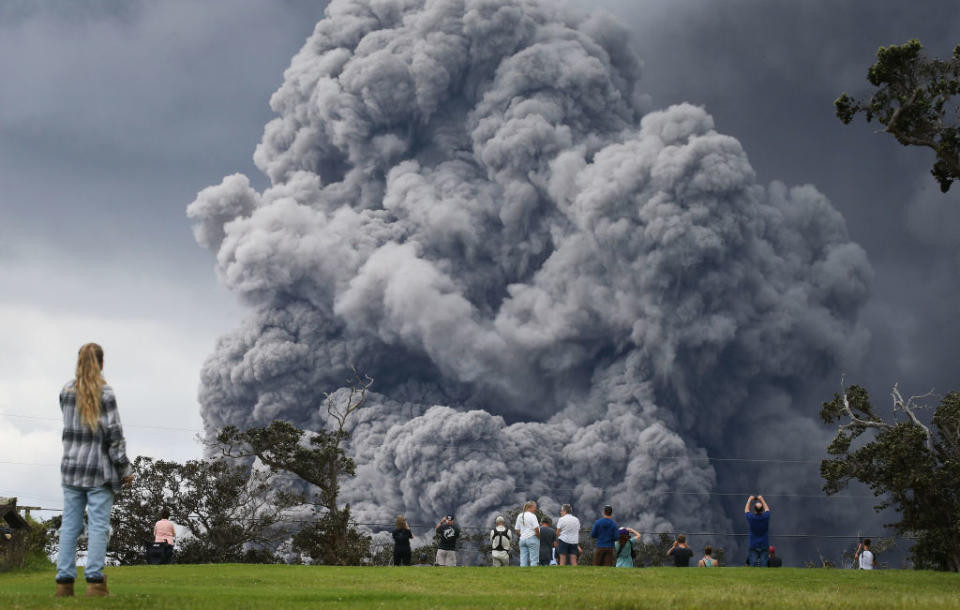 <p>People watch at a golf course as an ash plume rises in the distance from the Kilauea volcano on Hawaii’s Big Island on May 15, 2018 in Hawaii Volcanoes National Park, Hawaii. The U.S. Geological Survey said a recent lowering of the lava lake at the volcano’s Halemaumau crater ‘has raised the potential for explosive eruptions’ at the volcano. (Photo from Mario Tama/Getty Images) </p>