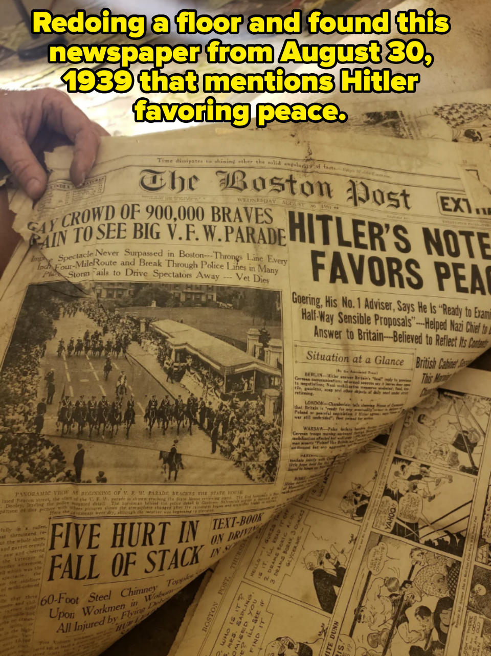 A person holds a copy of The Boston Post newspaper with headlines about a big V.F.W. parade and Hitler's note favoring peace