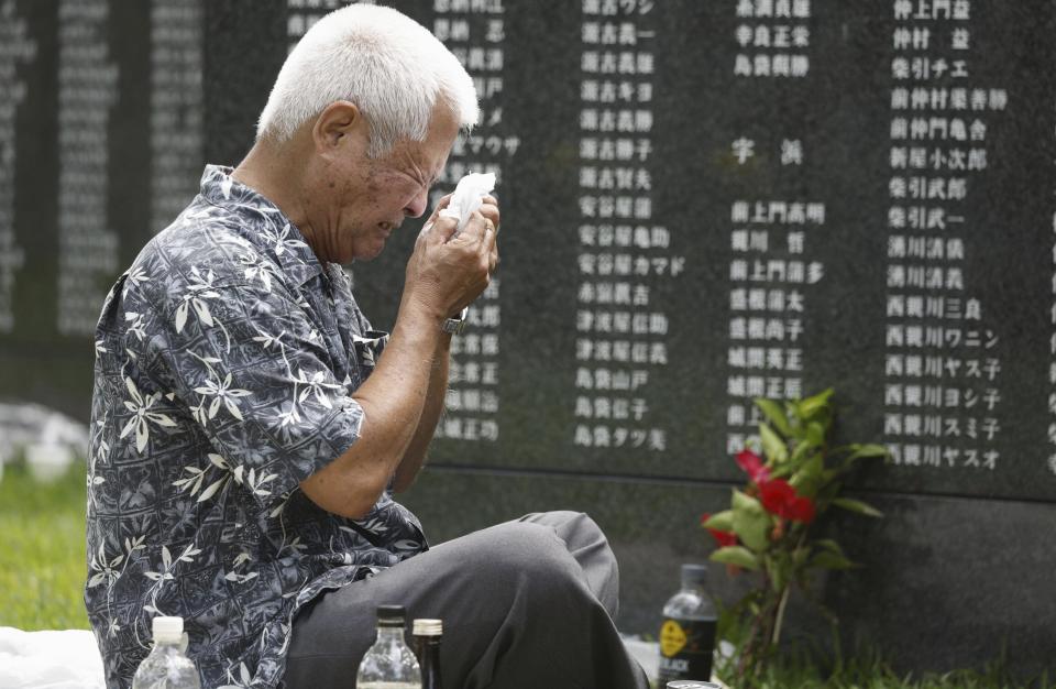 A man cries in front of the Cornerstone of Peace monument walls on which the names of all those who lost their lives during the Battle of Okinawa, at the Peace Memorial Park in Itoman, Okinawa prefecture, southern Japan Friday, June 23, 2023. Japan marked the Battle of Okinawa, one of the bloodiest battles of World War II fought on the southern Japanese island, which ended 78 years ago. (Kyodo News via AP)