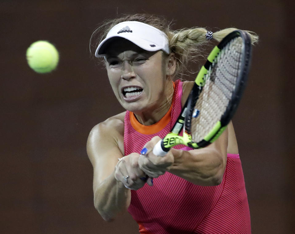 Caroline Wozniacki, of Denmark, hits a return to Ekaterina Makarova, of Russia, during the U.S. Open tennis tournament, Wednesday, Aug. 30, 2017, in New York. (AP Photo/Julio Cortez)