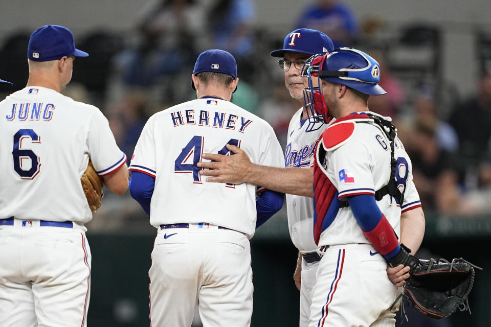 Texas Rangers' Josh Jung (6) and Mitch Garver, right, look on as starting pitcher Andrew Heaney (44) walks off the mound after turning the ball over to manager Bruce Bochy, second from right, in the seventh inning of a baseball game against the Chicago White Sox, Tuesday, Aug. 1, 2023, in Arlington, Texas. (AP Photo/Tony Gutierrez)