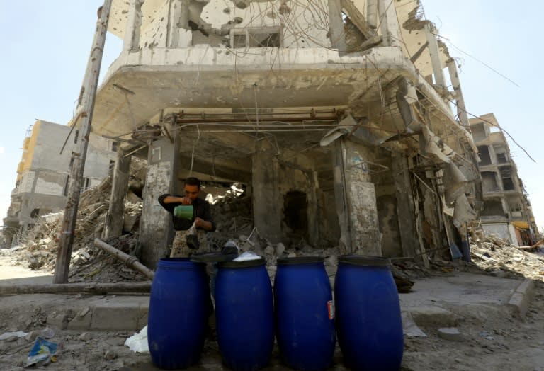 A man sells pickled vegetables at a market in the Syrian city of Raqa on May 17, 2018, during the holy month of Ramadan. US-backed forces ousted the Islamic State group from the devastated city in October