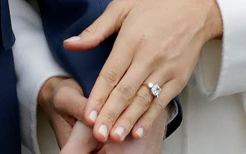 Prince Harry and his fiancee Meghan Markle hold hands as they pose for photographers - Credit: AP Photo/Matt Dunham