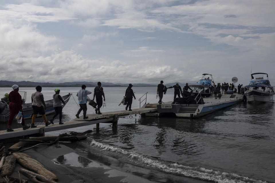 Migrantes abordan una embarcación rumbo al Tapón del Darién, en Necoclí, Colombia, el sábado 7 de octubre de 2023. (AP Foto/Iván Valencia)