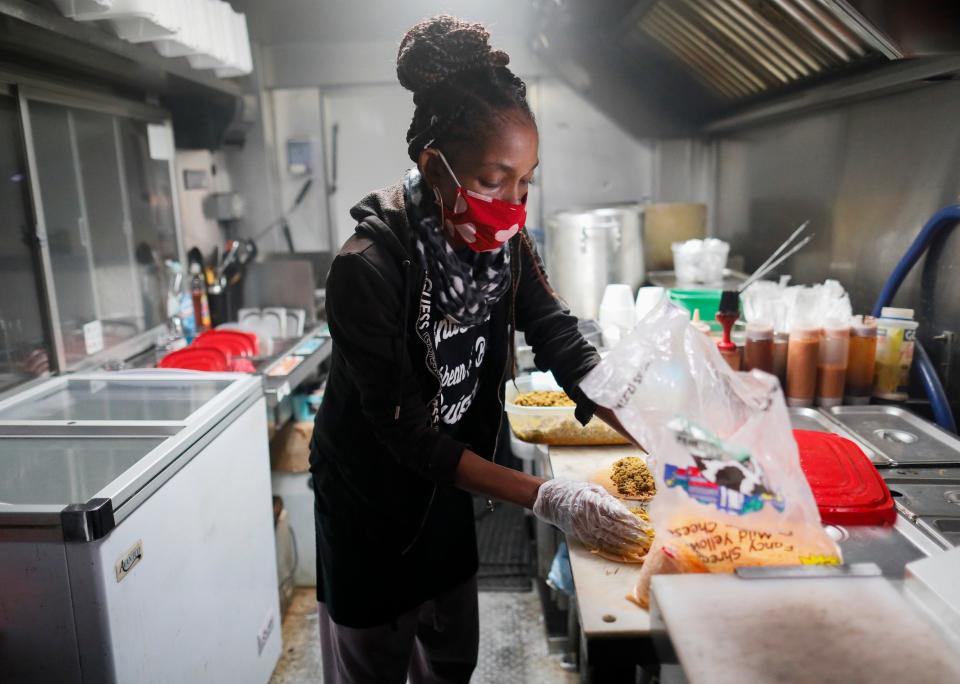 Shay Maley prepares an order for Nana's Patties & Things, a Reynoldsburg-area food truck that uses Trap Eats, a delivery service that promotes minority-owned businesses.