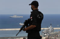 A Lebanese special forces policeman protecting UNESCO'S Director-General Audrey Azoulay, stands guards on the roof of a damaged school, that overlooks the site of the Aug. 4 explosion that hit the seaport, as Italian and French vessels are seen in the background, in Beirut, Lebanon, Thursday, Aug. 27, 2020. Azoulay is in Beirut for two days to mobilize the international community and make education, culture and heritage the main pillars of reconstruction efforts in the wake of the devastation. (AP Photo/Hussein Malla)