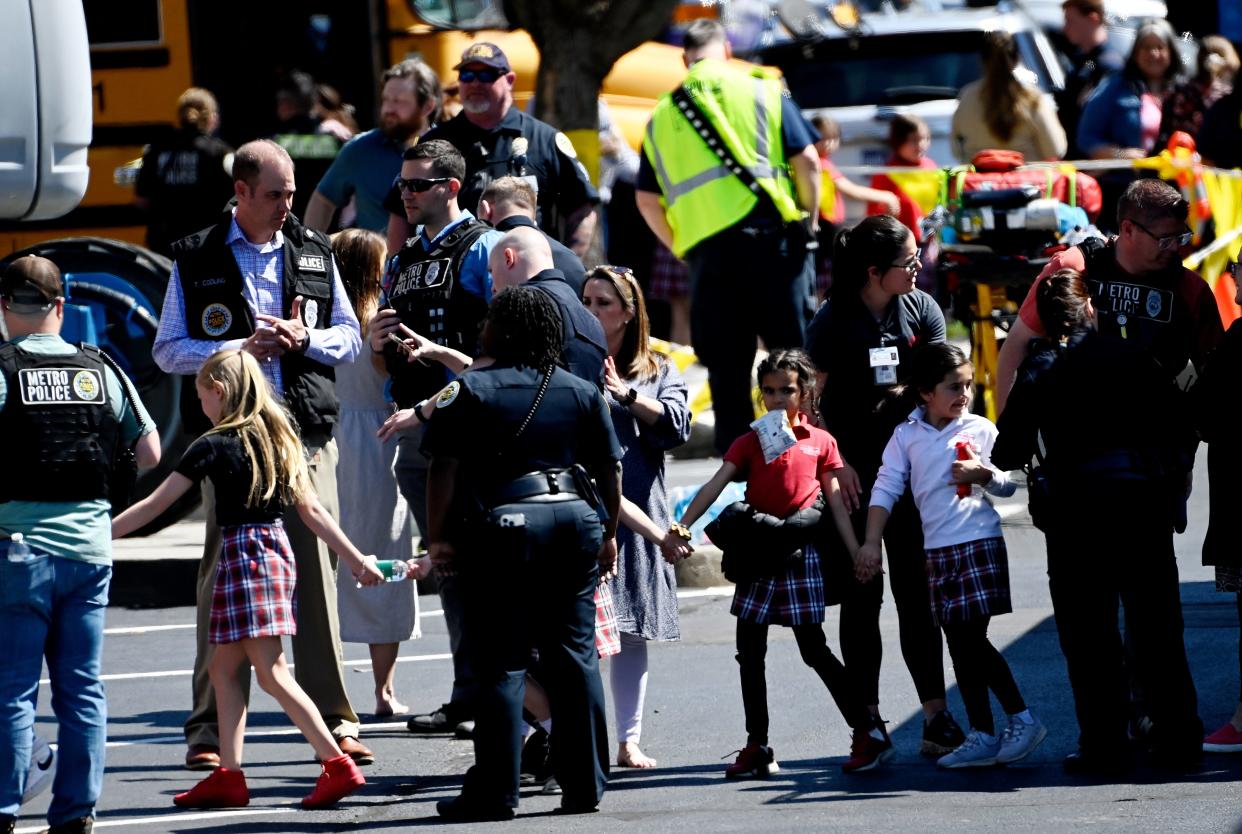 Students from the Covenant School hold hands after getting off a bus to meet their parents at the reunification site at the Woodmont Baptist Church Monday, March 27, 2023, in Nashville, Tenn.