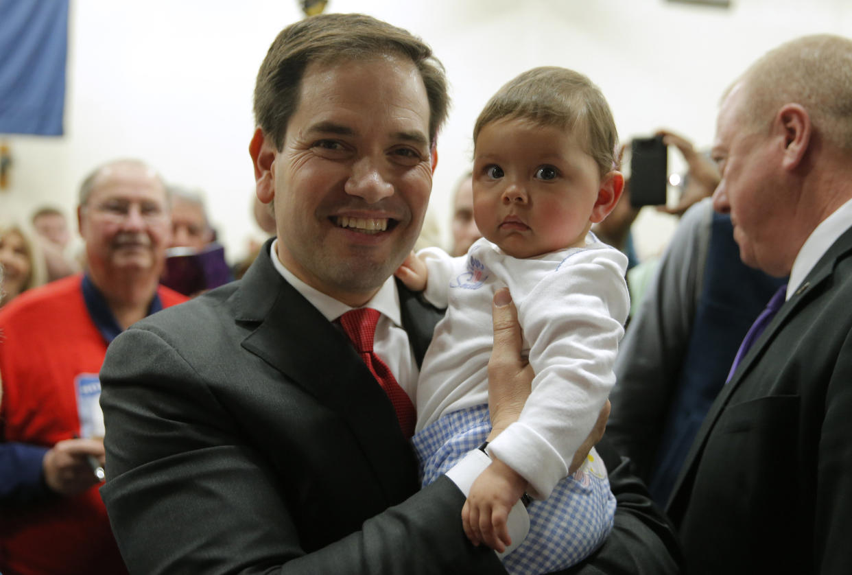 U.S. Republican presidential candidate Marco Rubio holds a baby as he greets supporters following a campaign town hall at the Odell Weeks Activity Center in Aiken, South Carolina February 17, 2016. REUTERS/Chris Keane