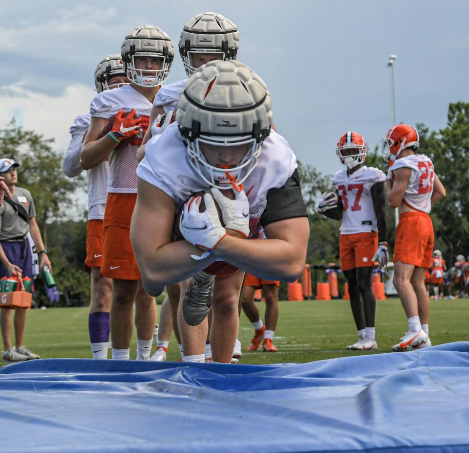 Clemson tight end Davis Allen (84) dives on a foam pad in a ball security drill during practice at the Poe Indoor Facility in Clemson Monday, August 8, 2022. 