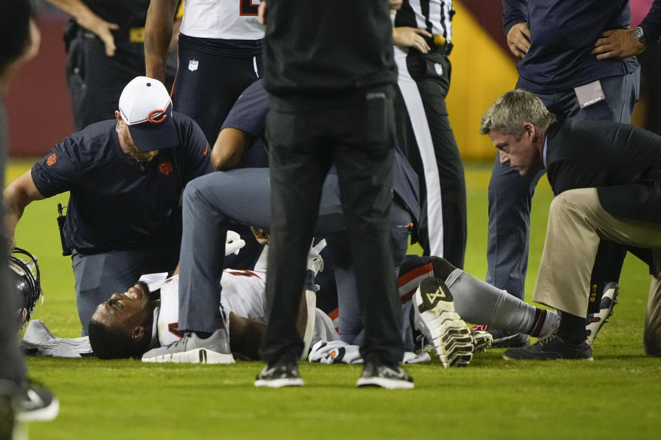 Chicago Bears running back Khalil Herbert (24) on the ground as he is examined by team officials after being injured on a play during the second half of an NFL football game against the Washington Commanders, Thursday, Oct. 5, 2023, in Landover, Md. (AP Photo/Andrew Harnik)