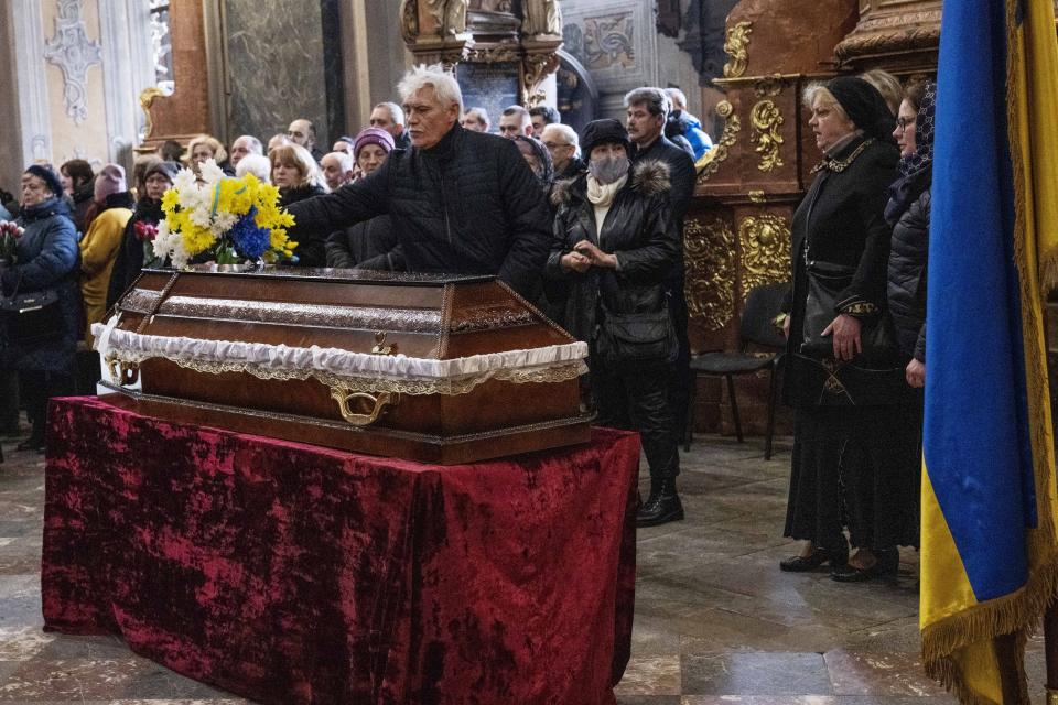 The family of 39-year-old Junior Sergeant Pohylenko Dmytro, killed in action, mourn his death during his funeral ceremony in the Holy Apostles Peter and Paul Church, in Lviv, western Ukraine, Saturday, April 2, 2022. (AP Photo/Nariman El-Mofty)