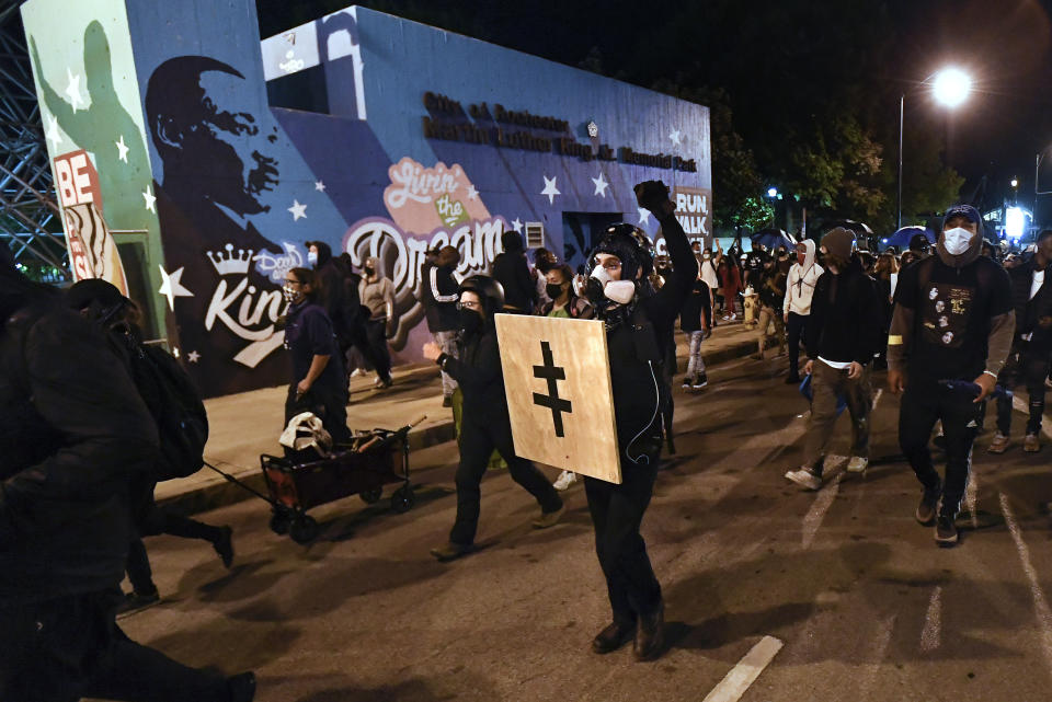 Demonstrators march past Dr. Martin Luther King, Jr. Memorial Park in Rochester, N.Y., Friday, Sept. 4, 2020, during a protest over the death of Daniel Prude. Prude apparently stopped breathing as police in Rochester were restraining him in March 2020 and died when he was taken off life support a week later. (AP Photo/Adrian Kraus)