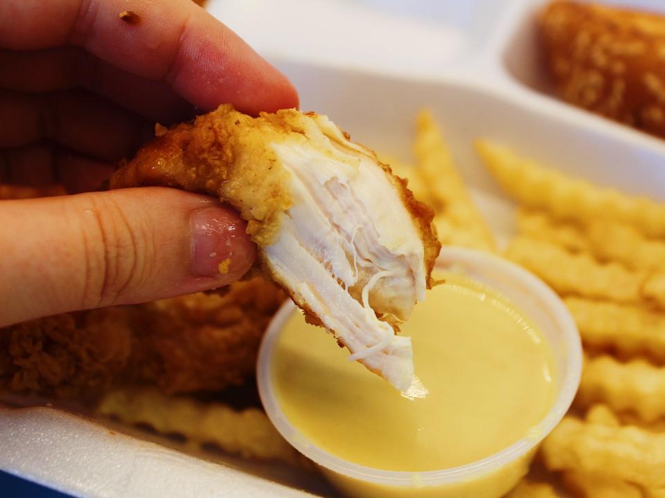 raising canes chicken tender dipped in honey mustard