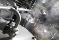 Sebastien Morvan, one of the founders of microbrewery Brussels Beer Project, looks into a tank during the brewing of a beer called Babylone at Bier Anders brewery in Halen April 16, 2015. REUTERS/Yves Herman