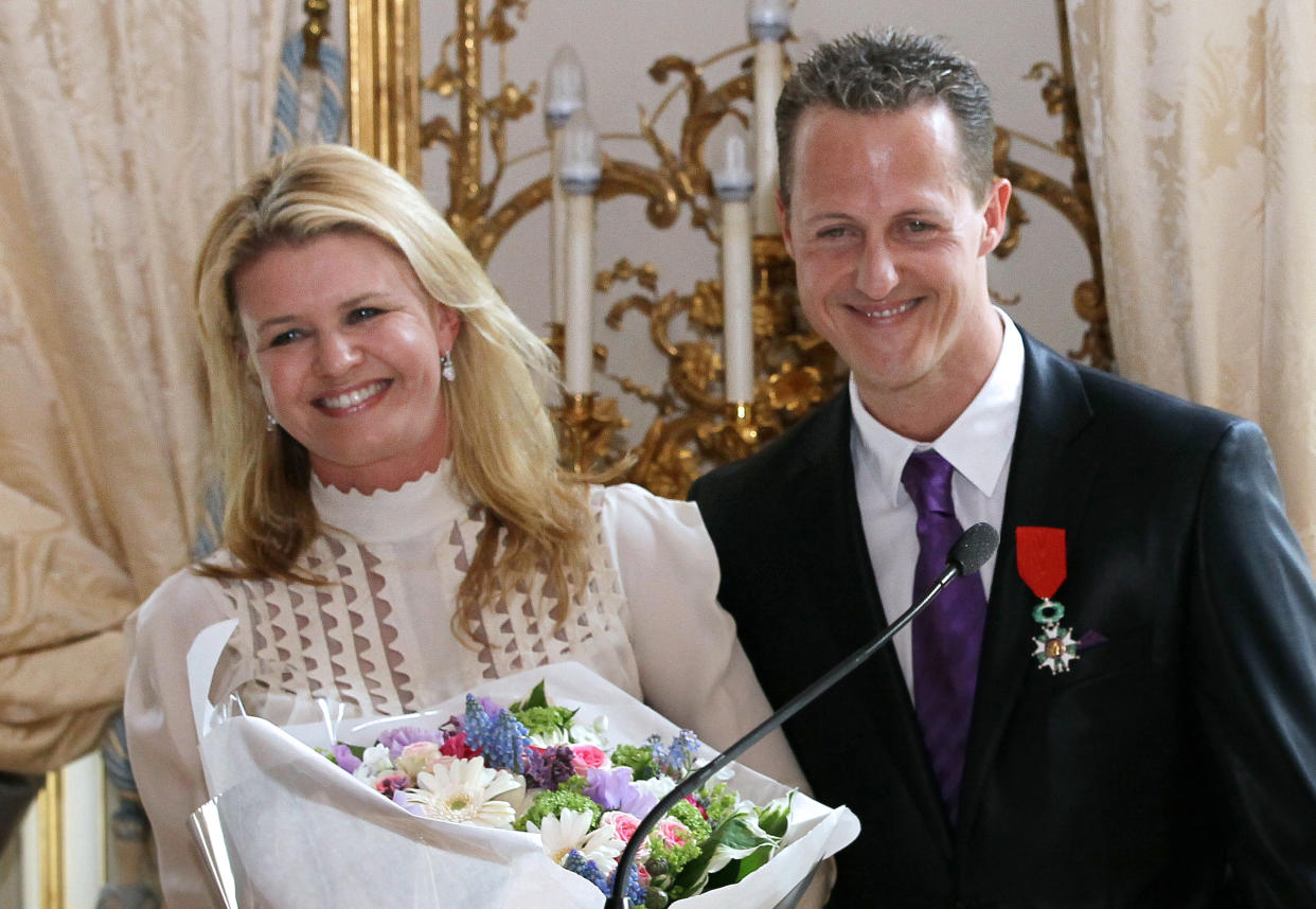 German Formula 1 pilot, Michael Schumacher poses with his wife Corinna after he was awarded with the French Legion of Honor by French Prime Minister Francois Fillon on April 29, 2010 at the Hotel Matignon in Paris. AFP PHOTO THOMAS COEX        (Photo credit should read THOMAS COEX/AFP/GettyImages)