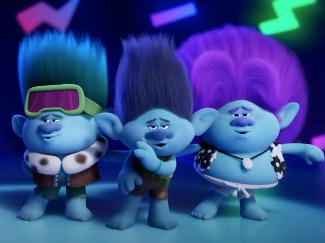 john dory, branch, and bruce in trolls band together. they're all blue trolls with voluminous hair that sticks straight up, dancing together on a stage