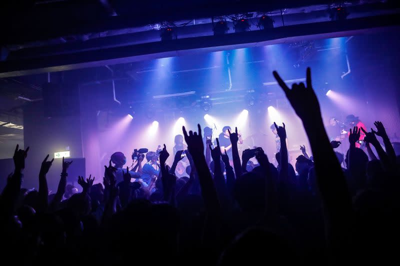 Fans wearing protective masks enjoy a band's performance at Hidden Agenda: This Town Needs (TNN) Live House during the club's last concert as business plummets due to the fear of the coronavirus, in Hong Kong