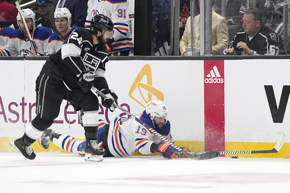 Edmonton Oilers center Adam Henrique, right, falls as Los Angeles Kings center Phillip Danault takes the puck during the firs period in Game 3 of an NHL hockey Stanley Cup first-round playoff series Friday, April 26, 2024, in Los Angeles. (AP Photo/Mark J. Terrill)