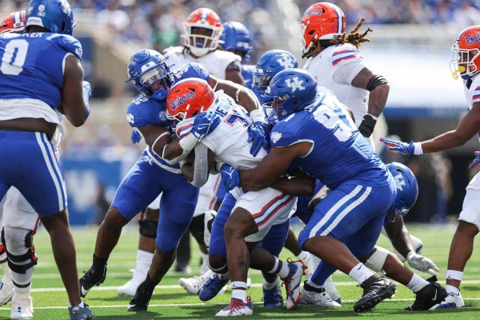 Kentucky linebacker Trevin Wallace (32) tackles Florida running back Trevor Etienne (7) during Saturday’s game at Kroger Field.