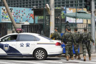 Chinese military personnel past by the United States Embassy near a police car in Beijing, Wednesday, Aug. 3, 2022. U.S. House Speaker Nancy Pelosi arrived in Taiwan late Tuesday, becoming the highest-ranking American official in 25 years to visit the self-ruled island claimed by China, which quickly announced that it would conduct military maneuvers in retaliation for her presence. (AP Photo/Ng Han Guan)