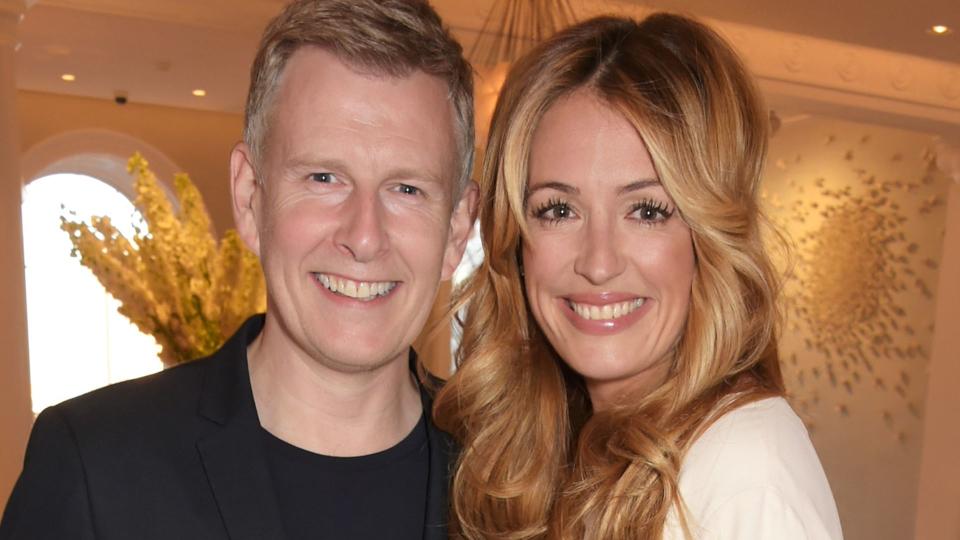 Patrick Kielty in a suit and Cat Deeley in a white mini dress and heels