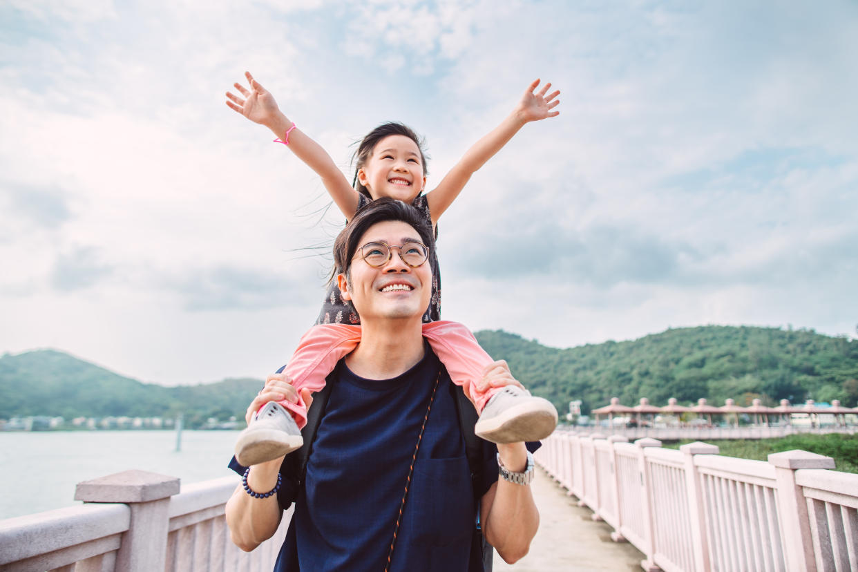 Little girl sitting on her dad’s shoulders. (Photo: Getty)