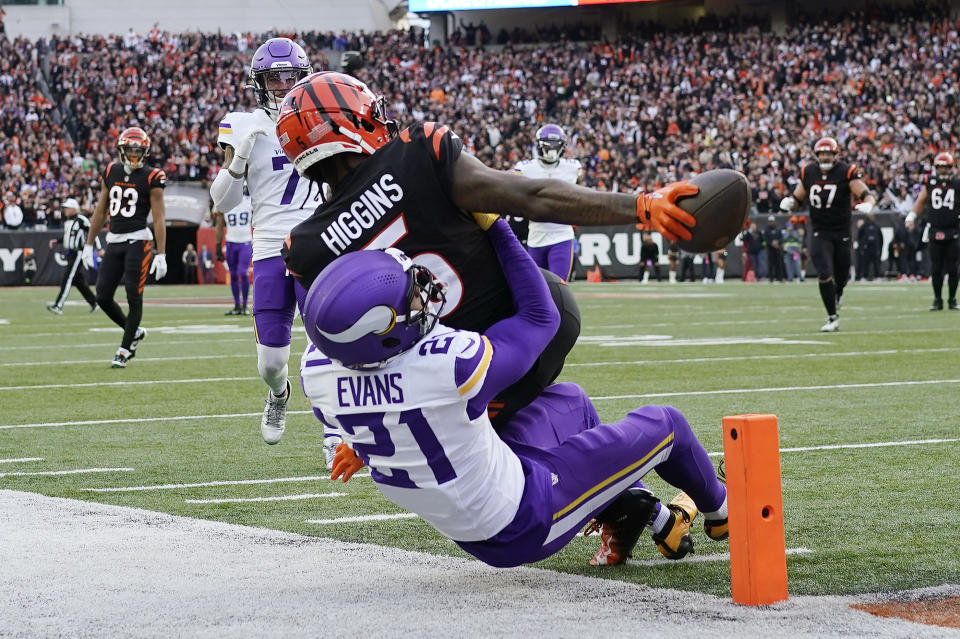 Cincinnati Bengals wide receiver Tee Higgins (5) reaches for the end zone to score a touchdown over Minnesota Vikings cornerback Akayleb Evans (21) of an NFL football game Saturday, Dec. 16, 2023, in Cincinnati. (AP Photo/Carolyn Kaster)