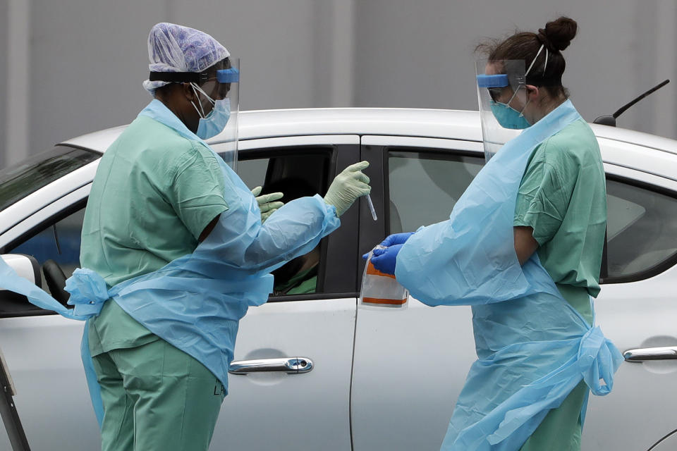 Staff members from Lakeland Regional Medical Center complete a COVID-19 test at a drive-thru site outside the R.P. Funding Center Monday, April 20, 2020, in Lakeland, Fla. The site is hoping to test 75 people a day. (AP Photo/Chris O'Meara)