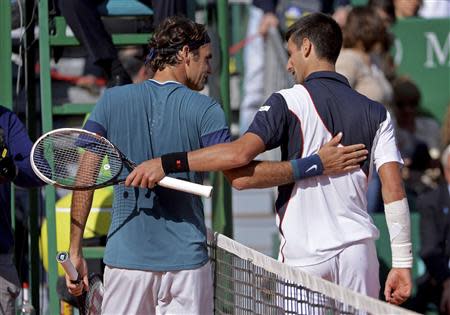 Novak Djokovic (R) of Serbia congratulates Roger Federer of Switzerland after their semi-final match at the Monte Carlo Masters in Monaco April 19, 2014. REUTERS/Patrice Masante