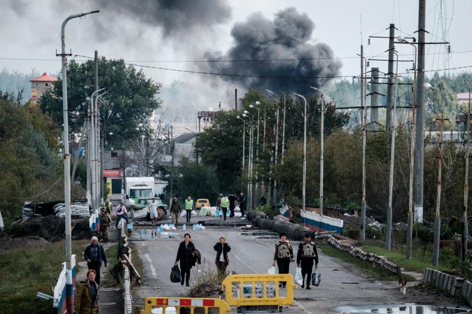 Ukrainian civilians in the city of Kupiansk evacuate after an explosion on a bridge over the Oskil River, Sept. 24
