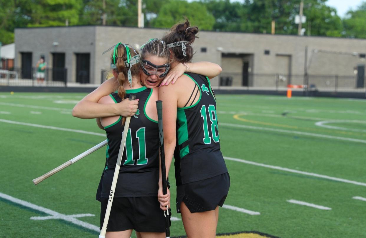 Elliot Chinnock (11) and Audrey Bajec (18) console Lily Holmes after Coffman's 17-7 loss at Upper Arlington on May 25 in the Division I, Region 3 final.