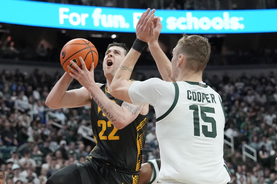 Iowa forward Patrick McCaffery (22) is defended by Michigan State center Carson Cooper (15) during the first half of an NCAA college basketball game, Tuesday, Feb. 20, 2024, in East Lansing, Mich. (AP Photo/Carlos Osorio)