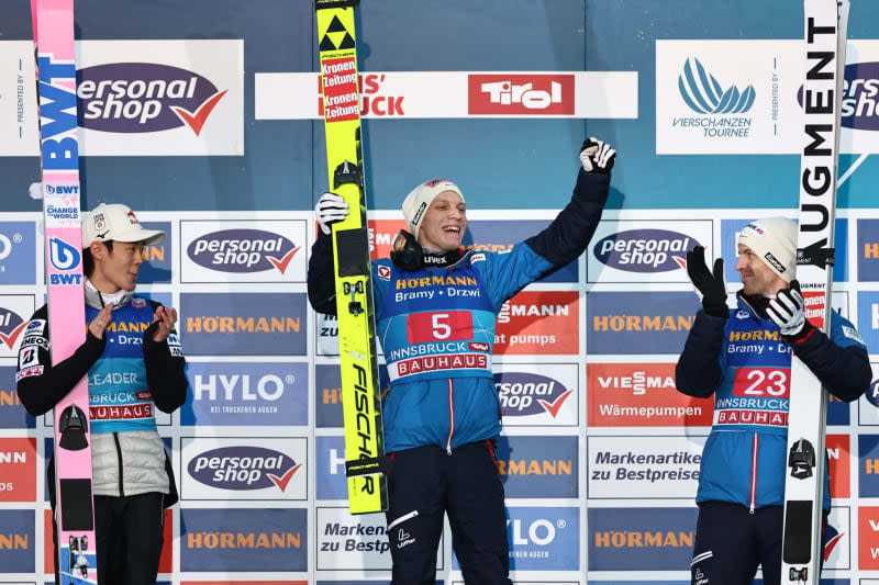 (L-R) Second placed Japan's Ryoyu Kobayashi, winner Austria's Jan Hoerl and third placed Austria's Michael Hayboeck celebrate on the podium after the third stage of the Four-Hills tournament as part of the FIS Ski Jumping World Cup. Daniel Karmann/dpa