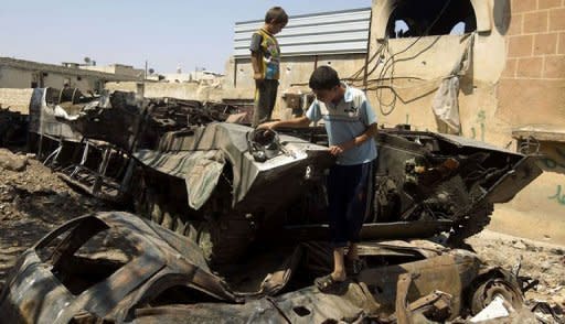 A handout picture released by the Syrian opposition's Shaam News Network shows boys playing on top of a destroyed tank in Atareb. AFP is using images from alternative sources. Syria's prime minister Riad Hijab has joined the anti-regime revolt and fled abroad, in what Washington and the opposition hailed as a major blow to President Bashar al-Assad