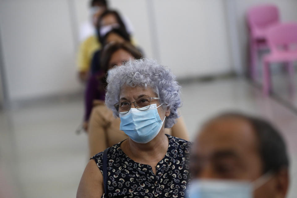 People wait in a recovery area after getting shots of the Johnson & Johnson vaccine at an inoculation center operated by the Portuguese armed forces at Lisbon University's sports stadium, Wednesday, June 23, 2021. The Lisbon region's recent surge in COVID-19 cases is powering ahead, with new infections pushing Portugal's number of daily cases to a four-month high, as a report by health experts found fault with the government's pandemic response. (AP Photo/Armando Franca)