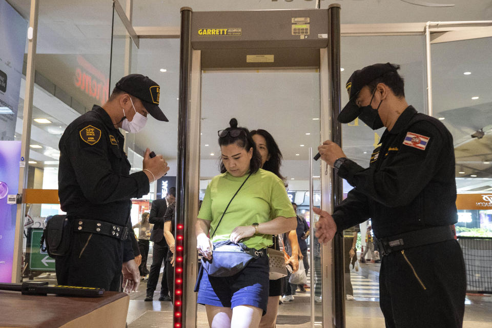 Security guards check a visitor's bag before allowing them into the Siam Paragon Mall in Bangkok, Thailand, Wednesday, Oct. 4, 2023, a day after a teenage boy with a handgun opened fire inside the major shopping mall. (AP Photo/Wason Wanichakorn)