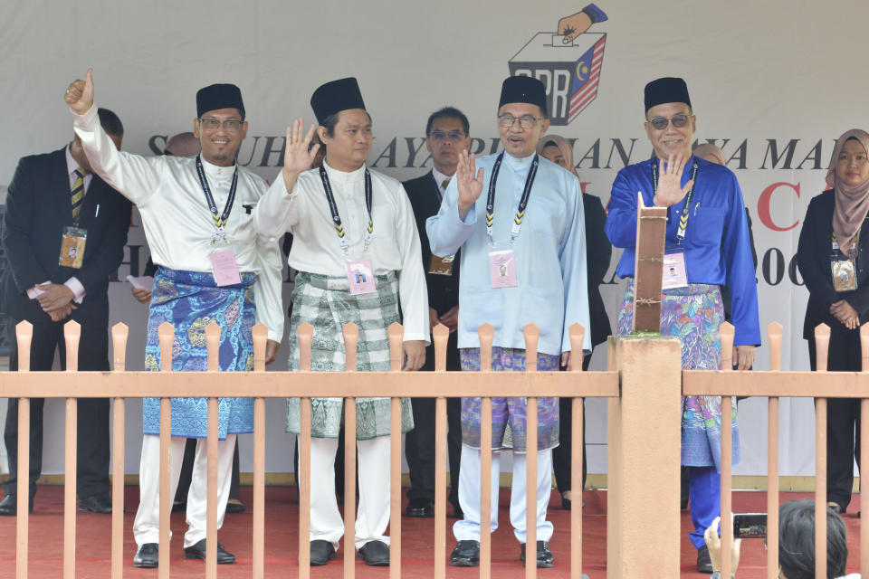 Datuk Seri Ahmad Faizal Azumu, Perikatan Nasional (National Alliance), from left, Abdul Rahim Tahir, Gerakan Tanah Air (Homeland Party), Malaysian opposition leader Anwar Ibrahim, Pakatan Harapan (Alliance of Hope) and Md Hanafiah, Barisan Nasional (National Front) wave to their supporters after the election nomination in Tambun, Malaysia, Saturday, Nov. 5, 2022. (AP Photo/JohnShen Lee)