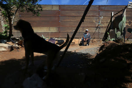 Pensioner Pedro, 72, rests outside his home near a section of the fence separating Mexico and the United States, on the outskirts of Tijuana, Mexico. REUTERS/Edgard Garrido