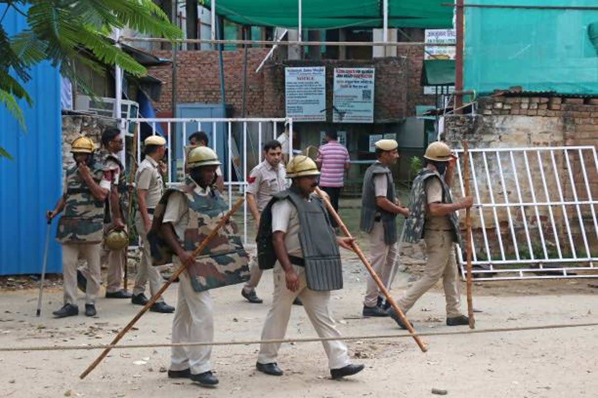 Police personnel stand guard outside a mosque after violent communal clashes in Gurgaon on 1 August 2023 (AFP via Getty Images)