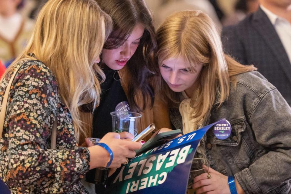 Supporters of U.S. Senate Democrat candidate Cheri Beasley from left, Ava Bowman Thomas, Emily Mintz and Haley Hendrick look at early election results during an election watch party Tuesday, Nov 8, 2022 at the Sheraton in downtown Raleigh.