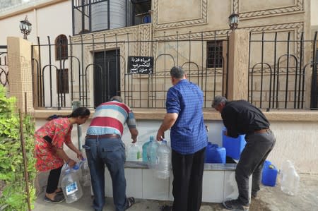People fill gallons with water during a water shortage in Tripoli