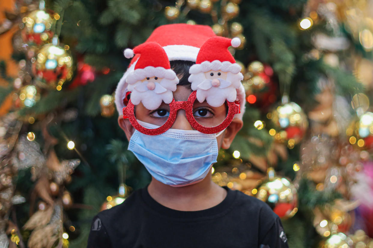  A boy wearing a face mask and Christmas decorative eye glasses at a shopping mall, amid the coronavirus crisis. (Photo by Annice Lyn / SOPA Images/Sipa USA) 