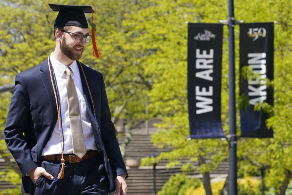 FILE - In this May 13, 2021, file photo, recent University of Akron graduate Matthew Yokosuk poses for photo on campus, in Akron, Ohio. In the week after Ohio Gov. Mike announced a weekly $1 million prize and full-ride college scholarships to entice more Ohioans to get the COVID-19 vaccine, the number of Ohioans age 16 and older who started the coronavirus vaccination process jumped 33 per cent. However, vaccination rates are still well below where they were in March and most of April, an analysis shows. (AP Photo/Tony Dejak, File)