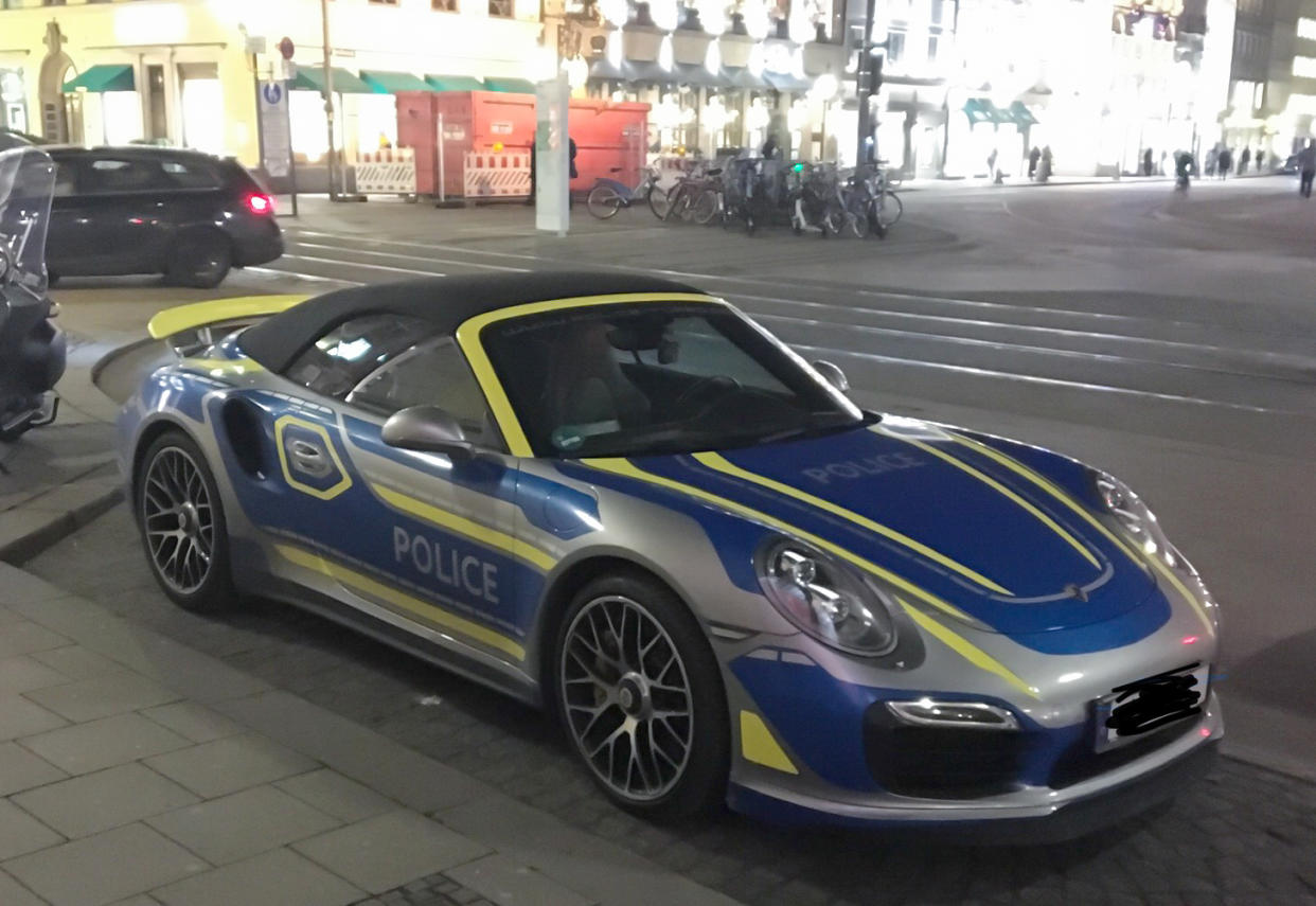 Ein Porsche mit der Beschriftung "Police", der auf den ersten Blick wie ein Polizeiauto aussieht, steht in München am Max-Joseph-Platz (Bild: Marie Schneider/Mucbook/dpa)