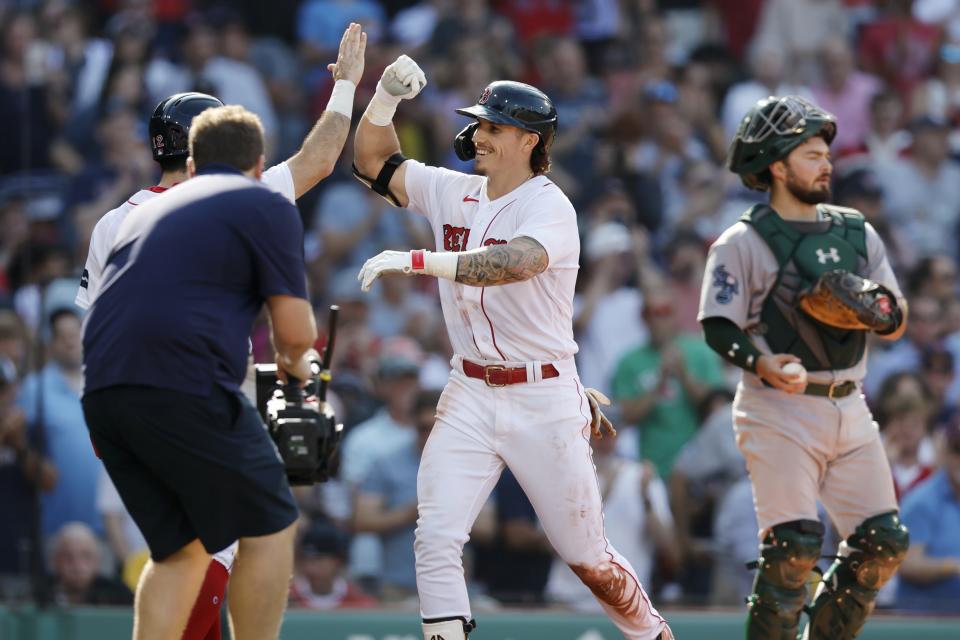 Boston Red Sox's Jarren Duran, center, celebrates his two-run home run beside Oakland Athletics' Shea Langeliers, right, during the second inning of a baseball game, Saturday, July 8, 2023, in Boston. (AP Photo/Michael Dwyer)