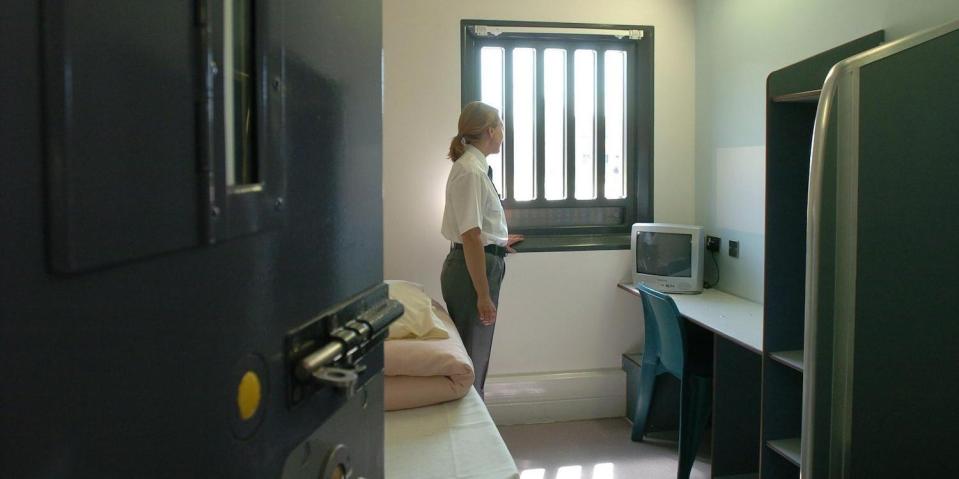 woman guard standing in prison cell HMP Bronzefield